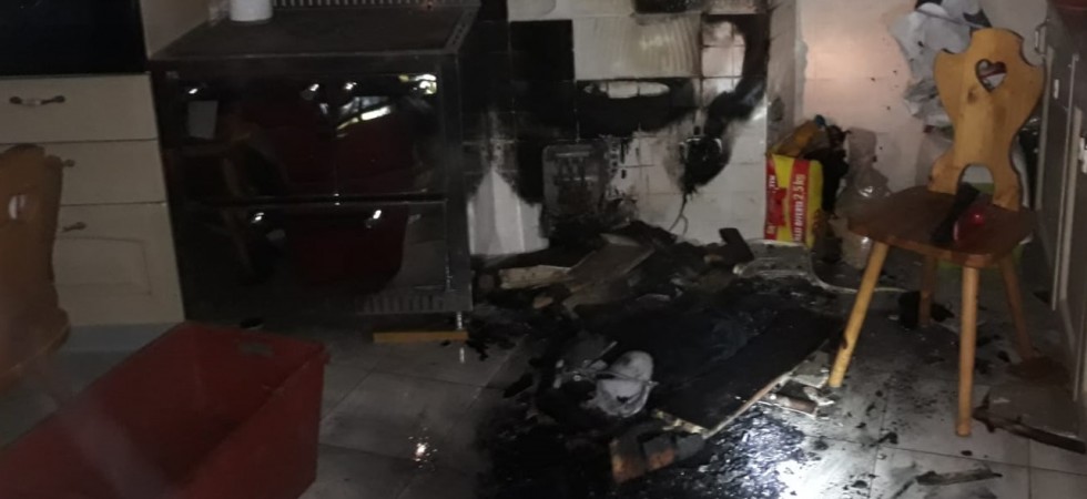Brace cade dalla stufa sulla cassa della legna, fiamme in un appartamento